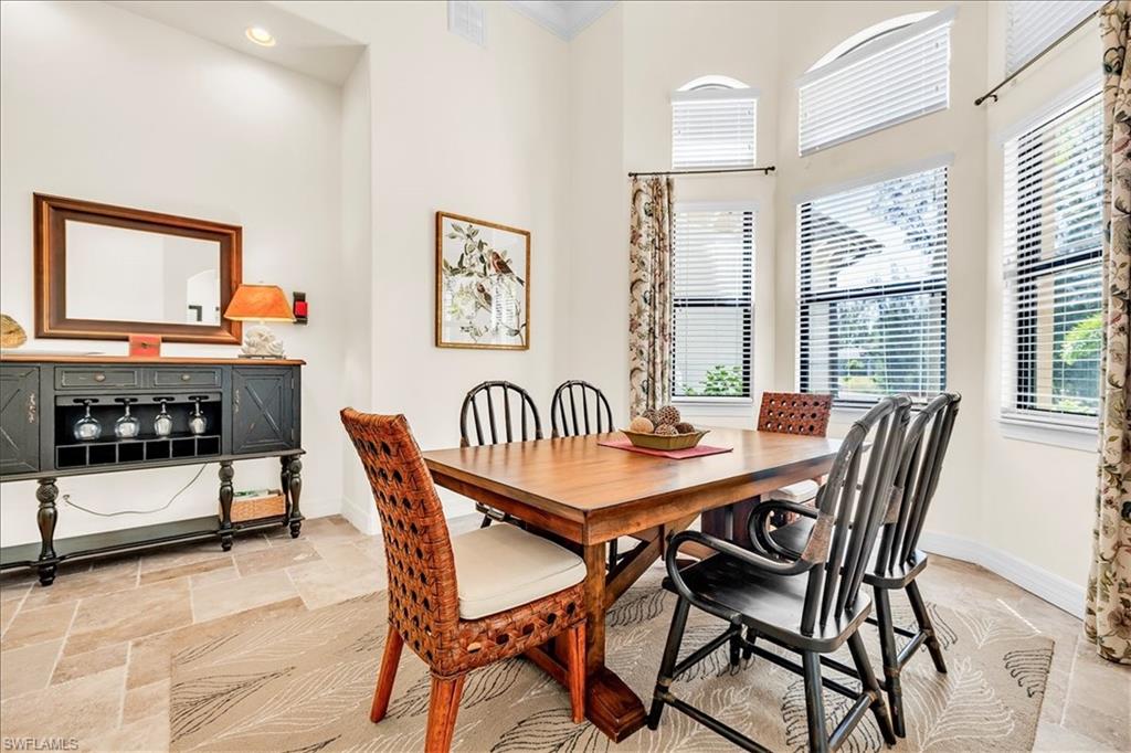 Dining area with large windows, vaulted ceiling, recessed lighting, and tile flooring