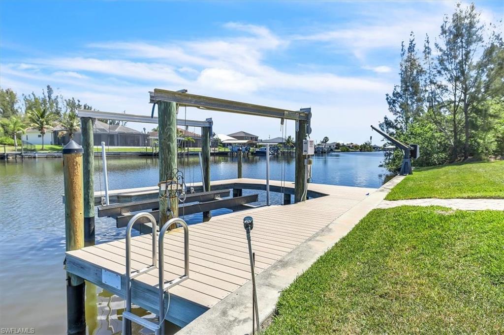 Waterfront property featuring a private boat dock with lift, stainless steel ladder, and a dedicated davit
