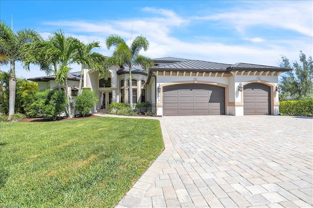 Contemporary stucco exterior featuring a dark metal roof and two-car garage