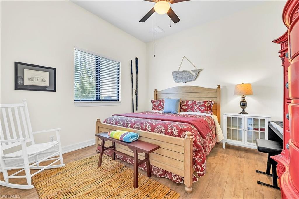 Spacious room with wood-finish flooring and a single window featuring horizontal blinds