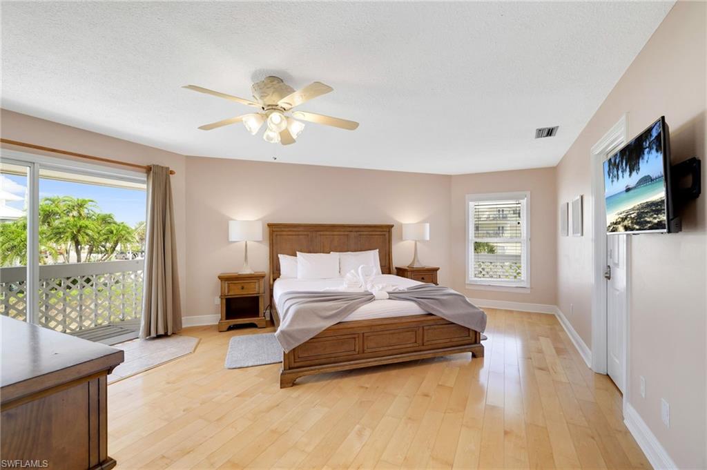 Bedroom with light wood-finish flooring and light-toned wall paint - Virtually Edited Image