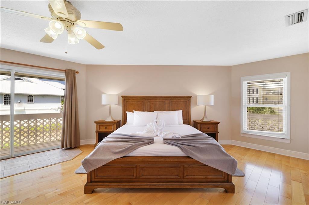 Spacious room featuring wood-finish flooring, a ceiling fan with integrated lighting, and neutral wall tones - Virtually Edited Image