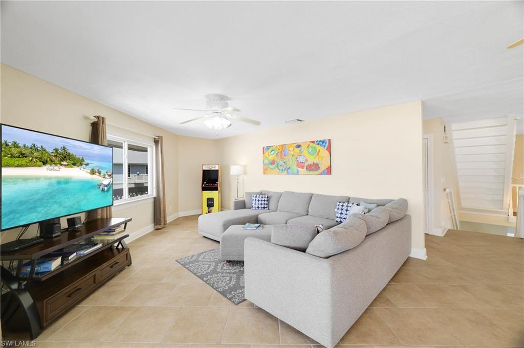 Spacious living area featuring light-toned walls and large tile flooring - Virtually Edited Image
