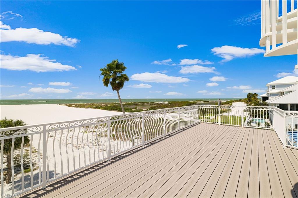Spacious outdoor deck featuring composite decking and an ornate white metal railing - Virtually Edited Image