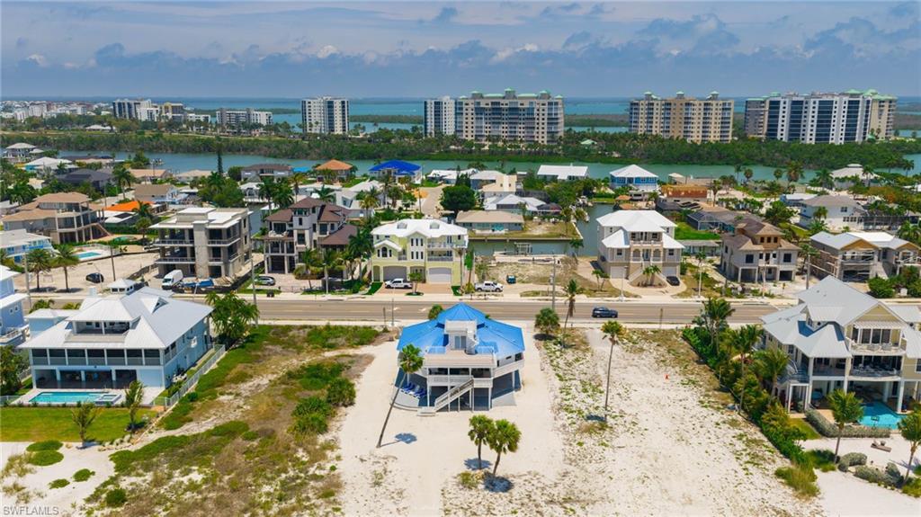 Aerial perspective showcasing a coastal community with numerous multi-story residences - Virtually Edited Image