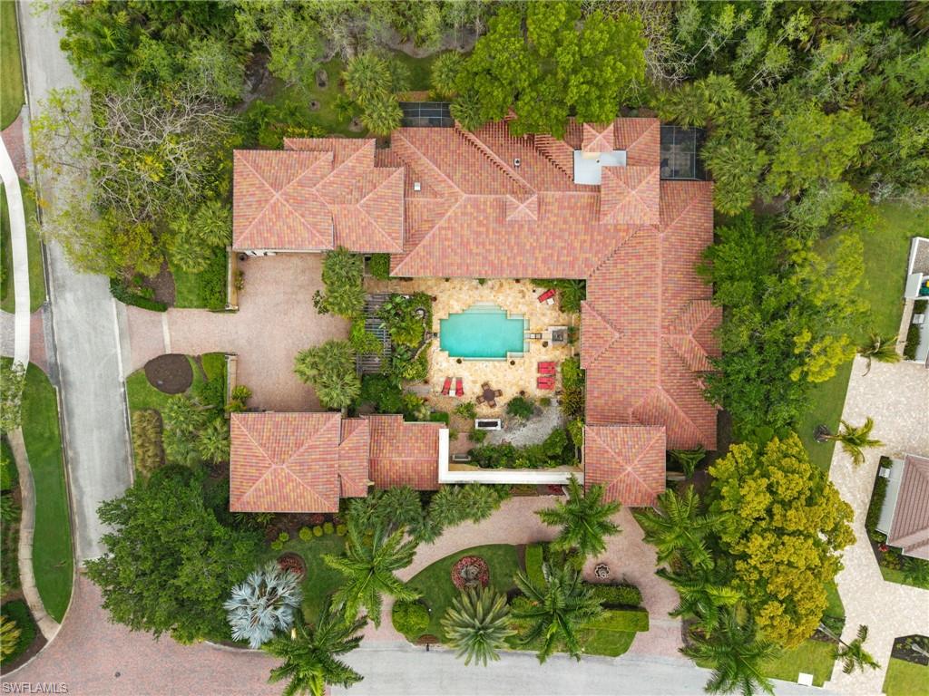 Expansive property featuring a central courtyard with an inground pool, surrounded by mature trees and lush landscaping