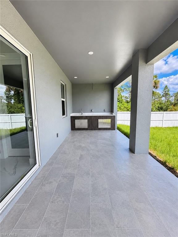 Covered patio featuring an outdoor kitchen with integrated sinks and stainless steel appliances