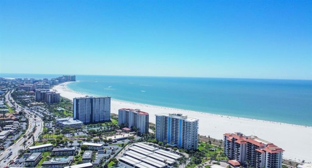 Bird eye view featuring a view of the beach, a water view, and a view of the city.