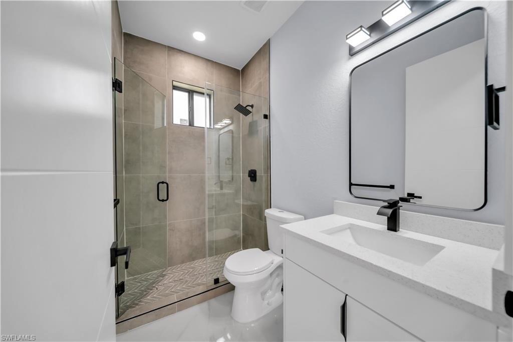 Full bathroom featuring a walk-in shower with glass enclosure, rain shower head, and herringbone tile floor