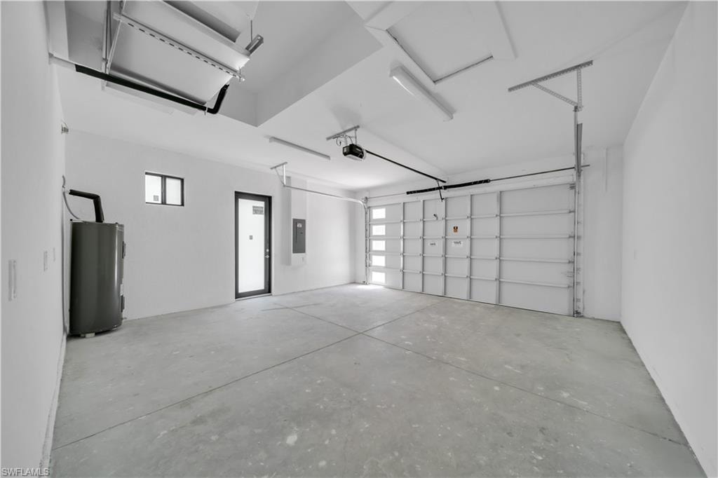 Spacious garage featuring a concrete floor, white painted walls, and a modern garage door with frosted glass panels