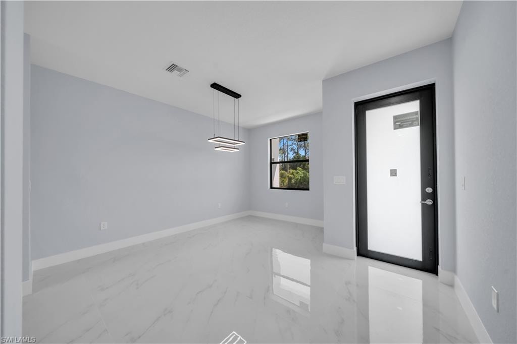 Entryway featuring light gray walls, white baseboards, and large format light-toned tile flooring