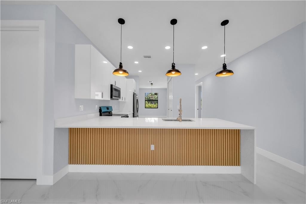 Spacious kitchen featuring a waterfall island with slatted wood detailing, integrated sink, and gooseneck faucet
