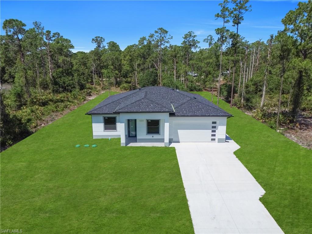 Contemporary single-story residence featuring a dark shingle roof and a light-colored exterior