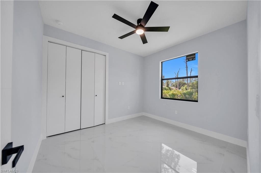 Room featuring light gray walls, white baseboards, and white tile flooring