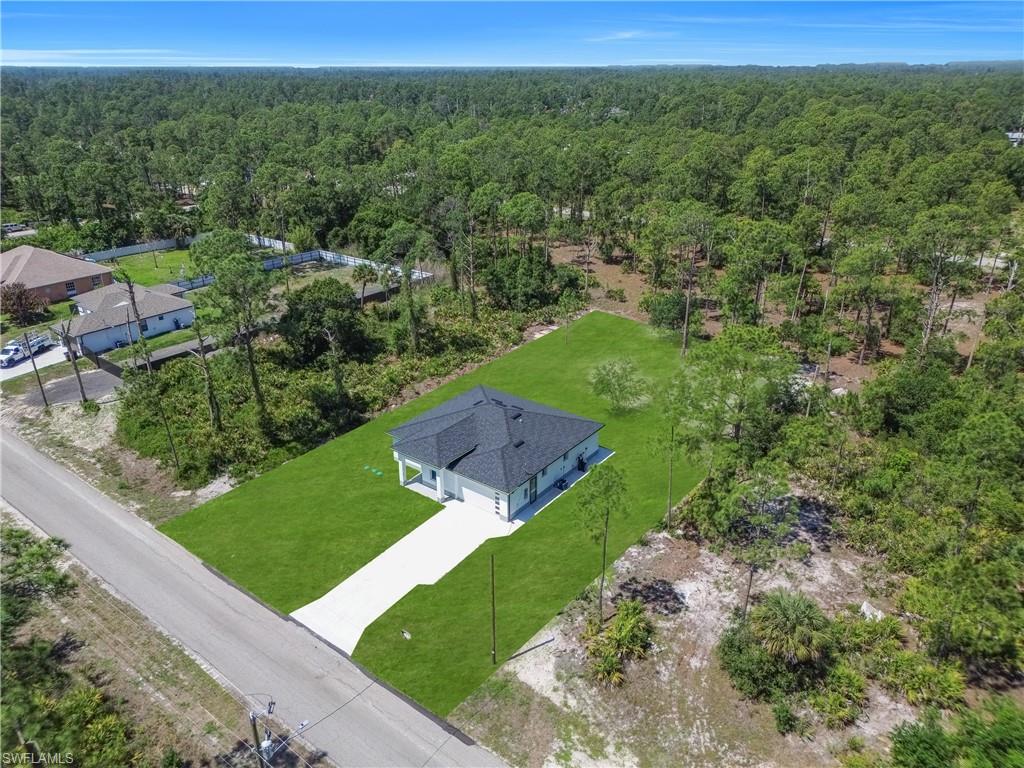 Contemporary single-story residence featuring a dark shingle roof and a concrete driveway
