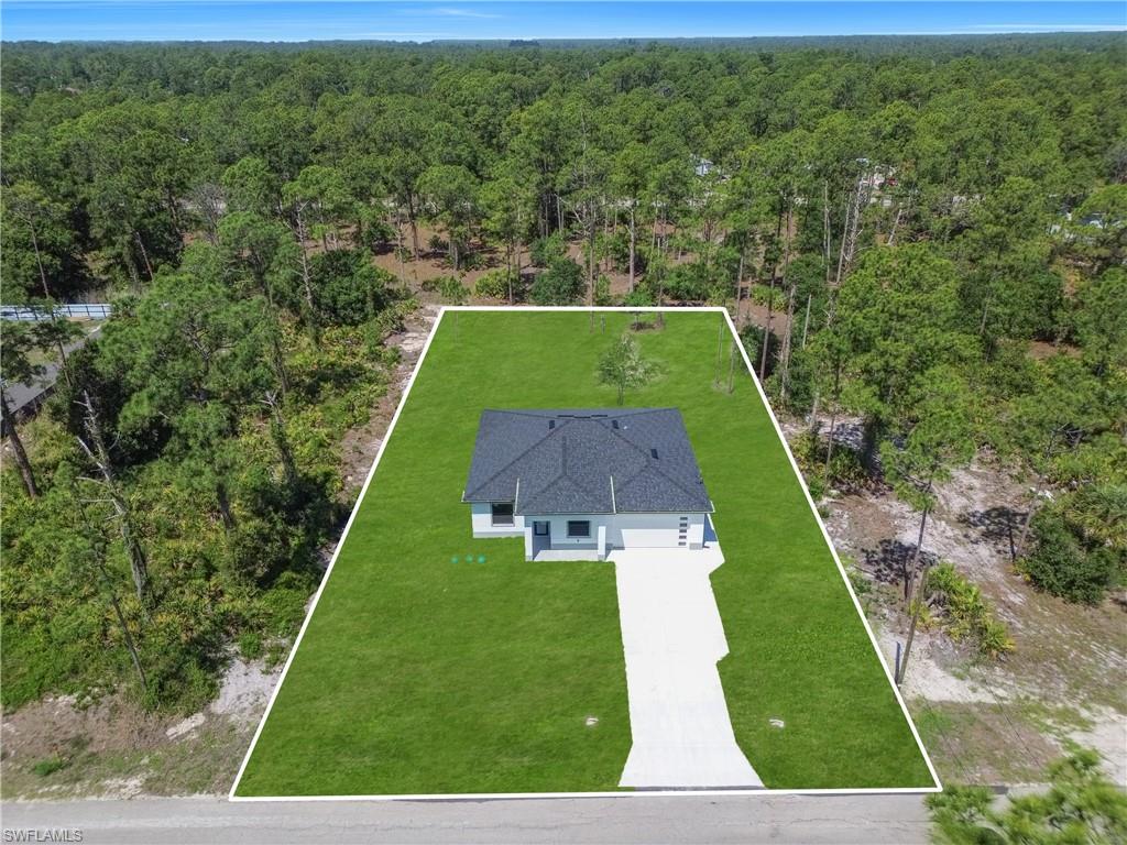 Newly constructed residence featuring a dark shingle roof, light-colored exterior, and an attached two-car garage