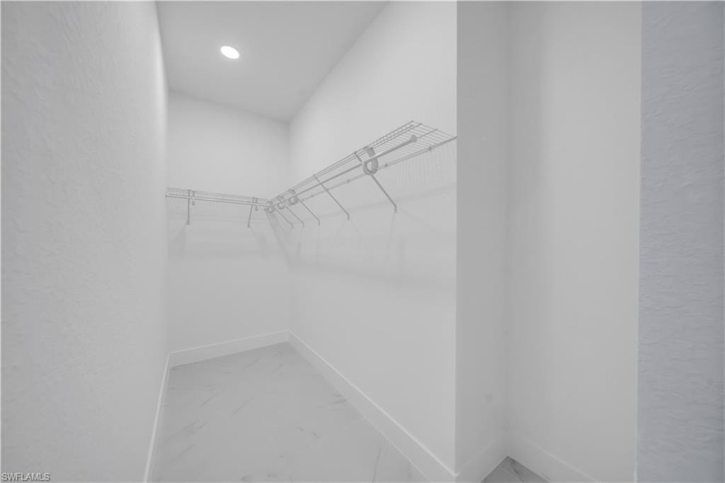 Walk-in closet featuring wire shelving, recessed lighting, and tile flooring