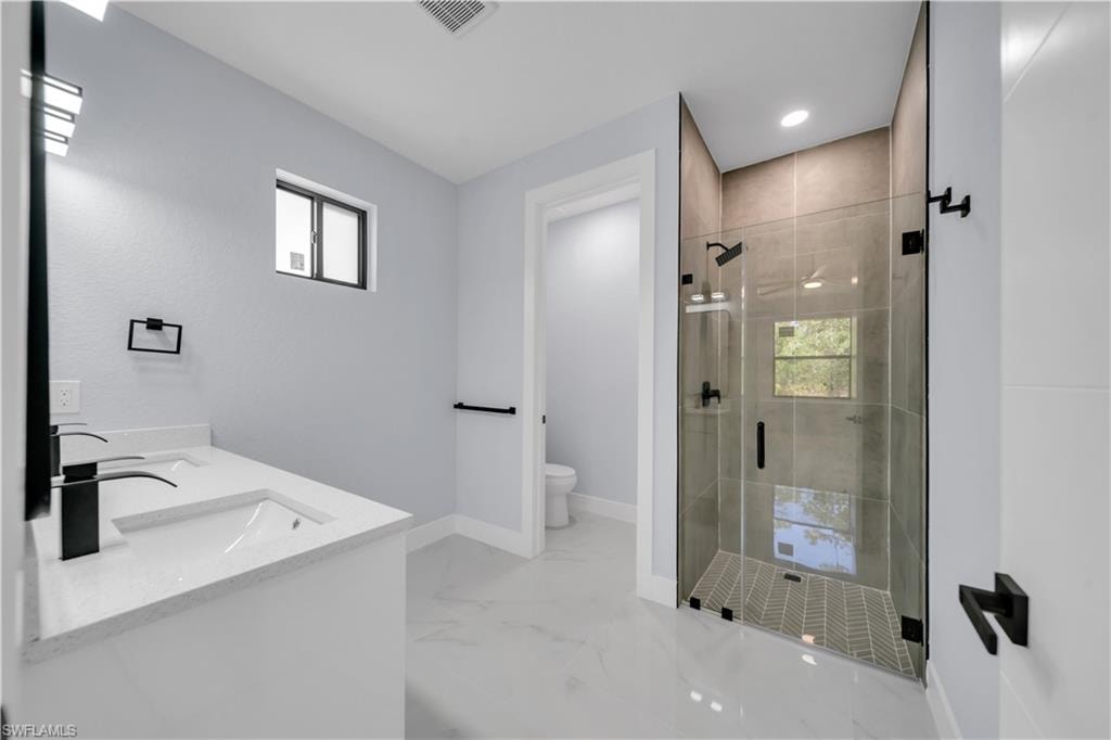 Contemporary bathroom featuring a spacious glass-enclosed shower with tiled walls and a herringbone-patterned shower pan