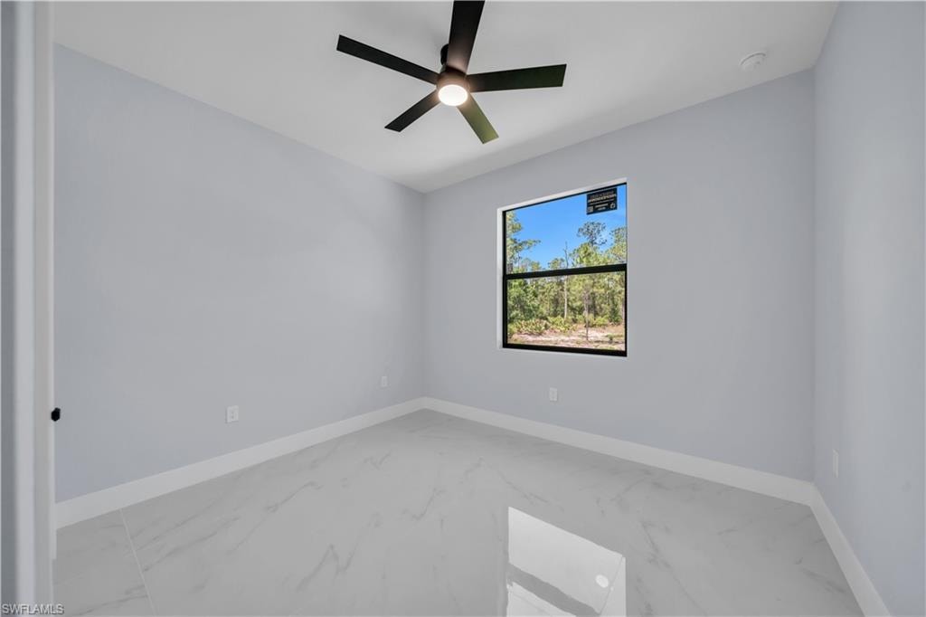 Room featuring light gray walls, white baseboards, and polished tile flooring