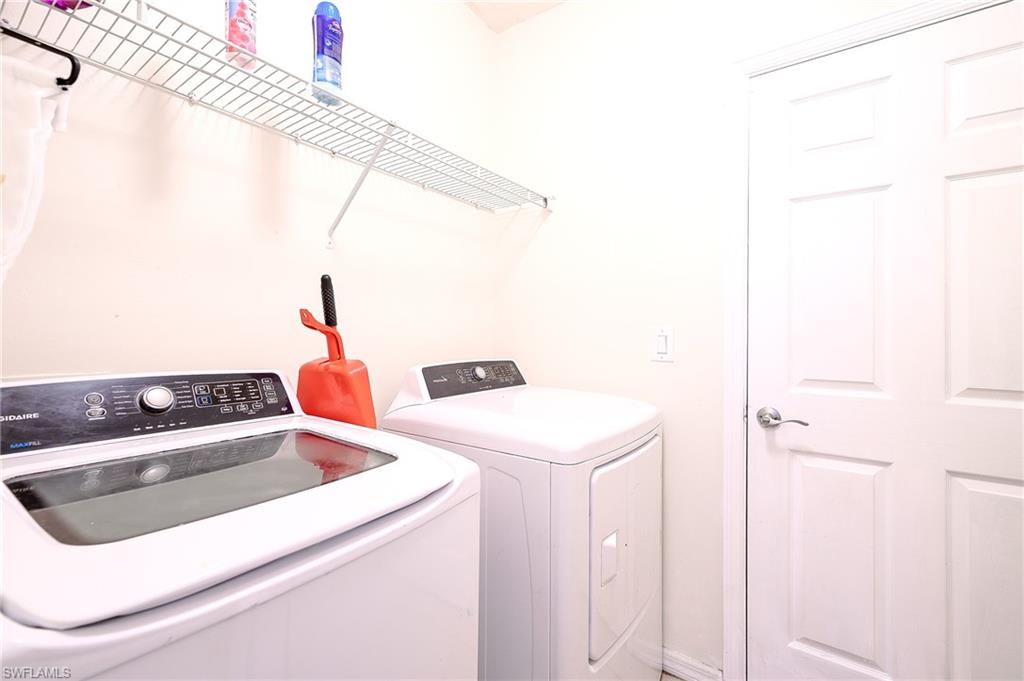 Dedicated laundry space featuring a white paneled door, light-toned walls, and a wire shelving unit