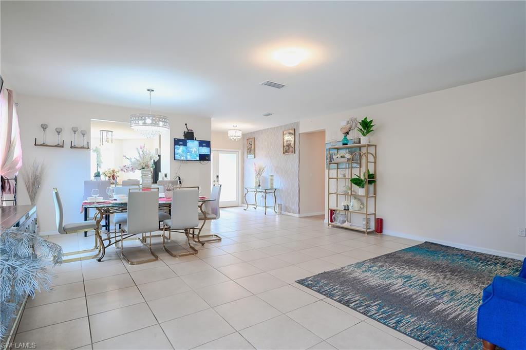 Open-concept living space featuring light-toned tile flooring throughout