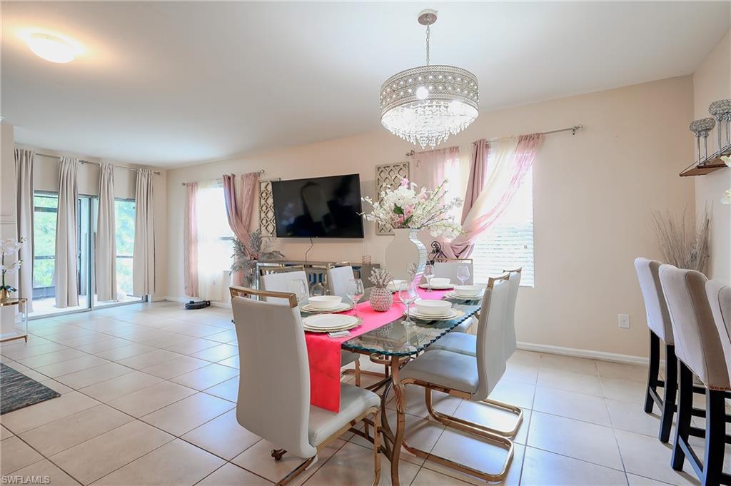 Bright dining area featuring a decorative chandelier and tile flooring