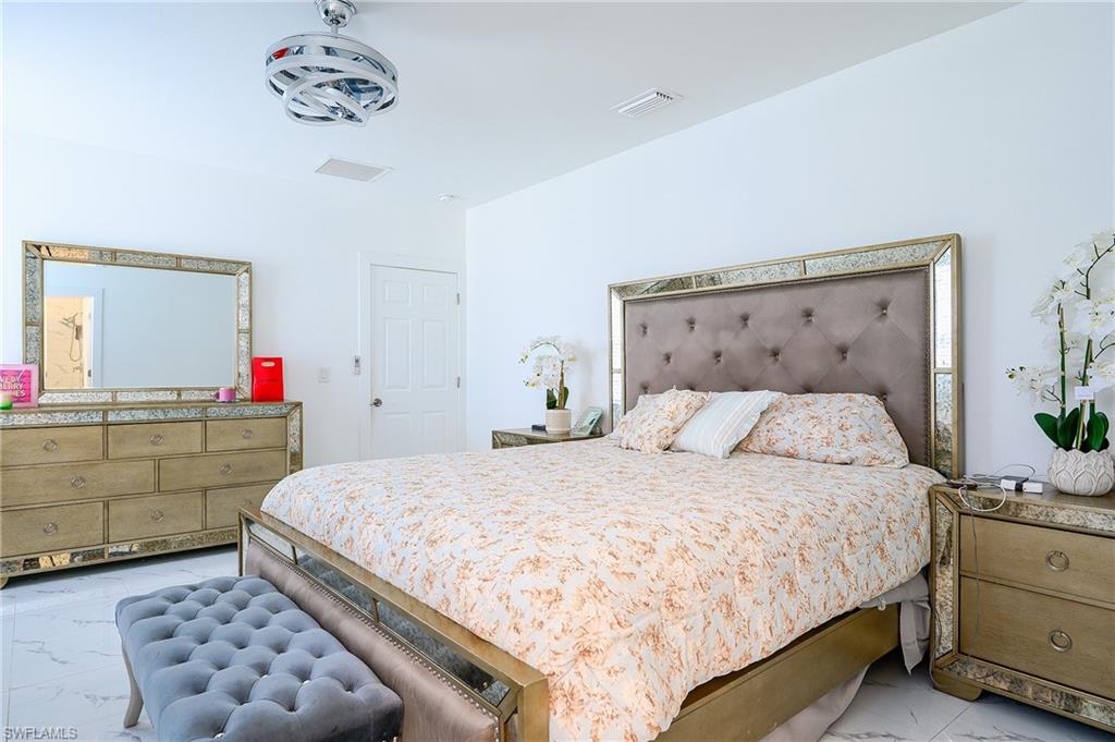 Spacious room featuring white walls, a white paneled door, and a modern ceiling fan
