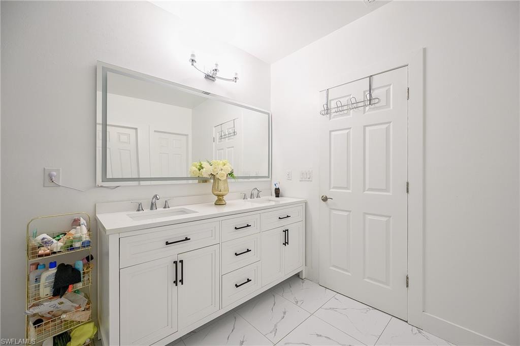Double vanity with integrated sinks and white cabinetry, featuring dark hardware