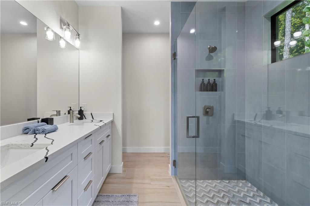 Double vanity with integrated sinks, white cabinetry, and a full-width mirror