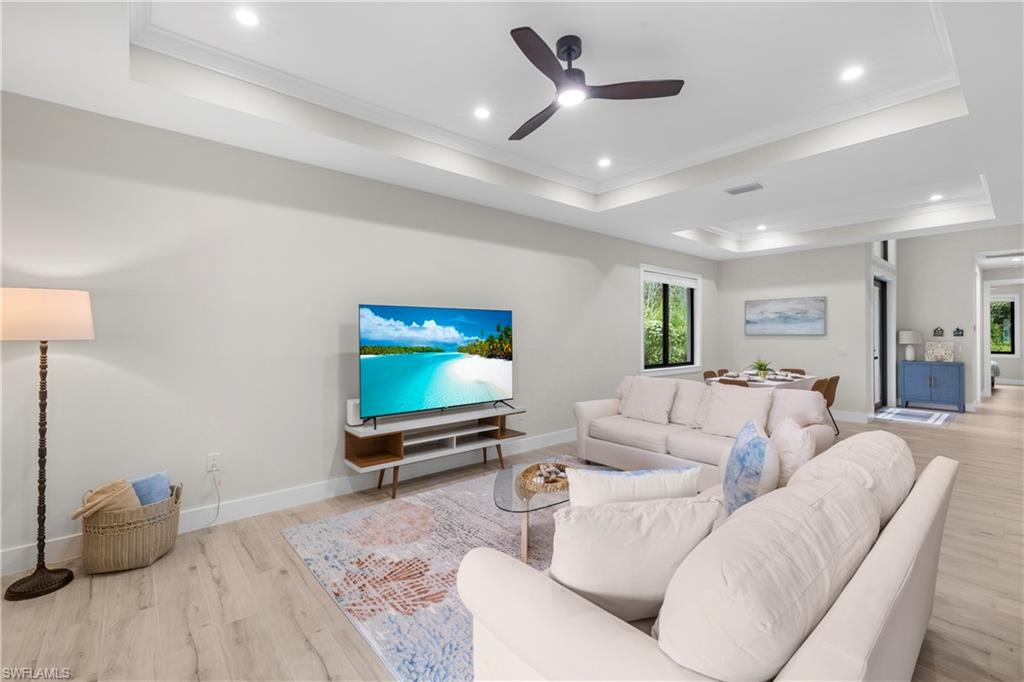 Expansive living area featuring light wood-finish flooring, recessed lighting, and a contemporary ceiling fan
