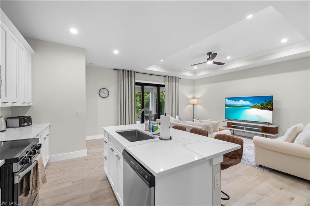 Spacious open-concept living area featuring wood-finish flooring and a kitchen island with seating