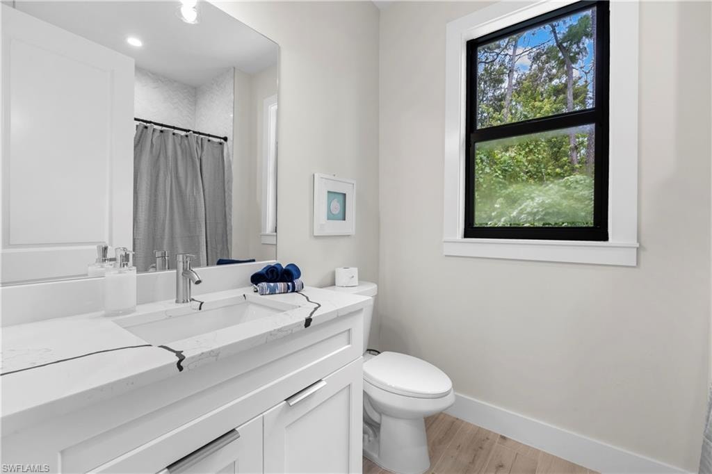 Bathroom vanity featuring an integrated rectangular sink, chrome faucet, and white cabinetry