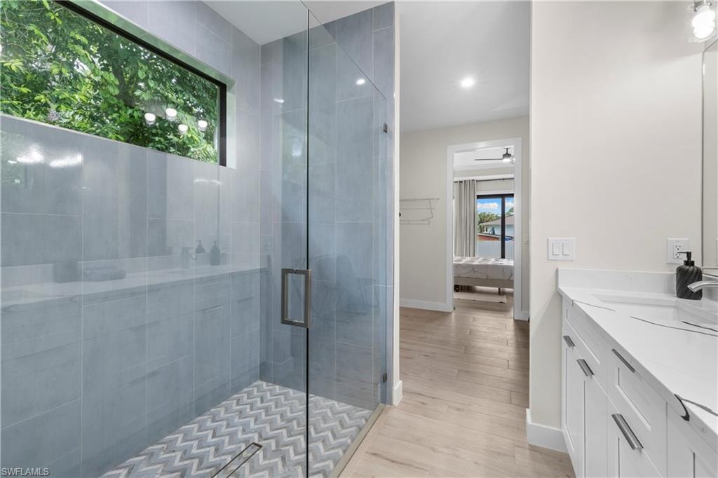 Contemporary bathroom featuring a glass-enclosed shower with a chevron-patterned tile floor and a horizontal window