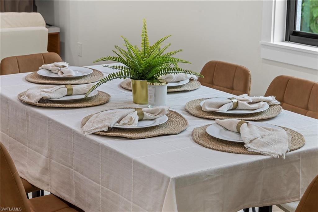 Dining area featuring a table with a light-colored tablecloth and upholstered chairs