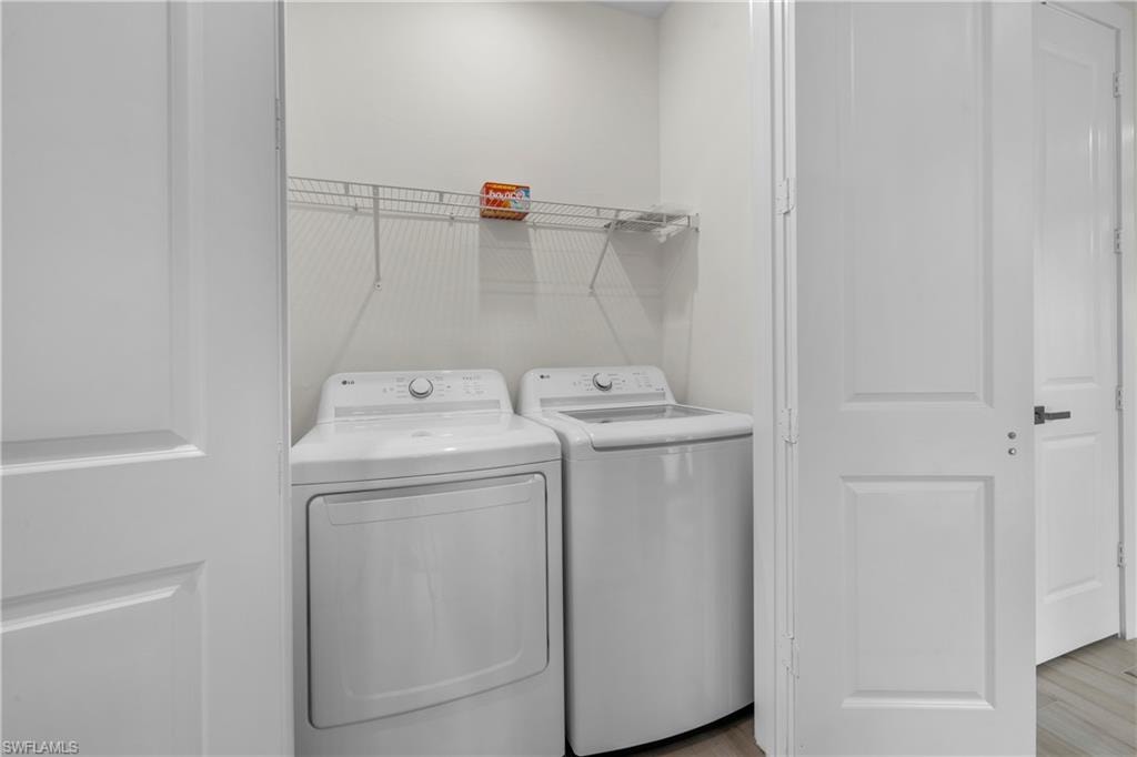 Dedicated laundry area featuring a white washer and dryer pair