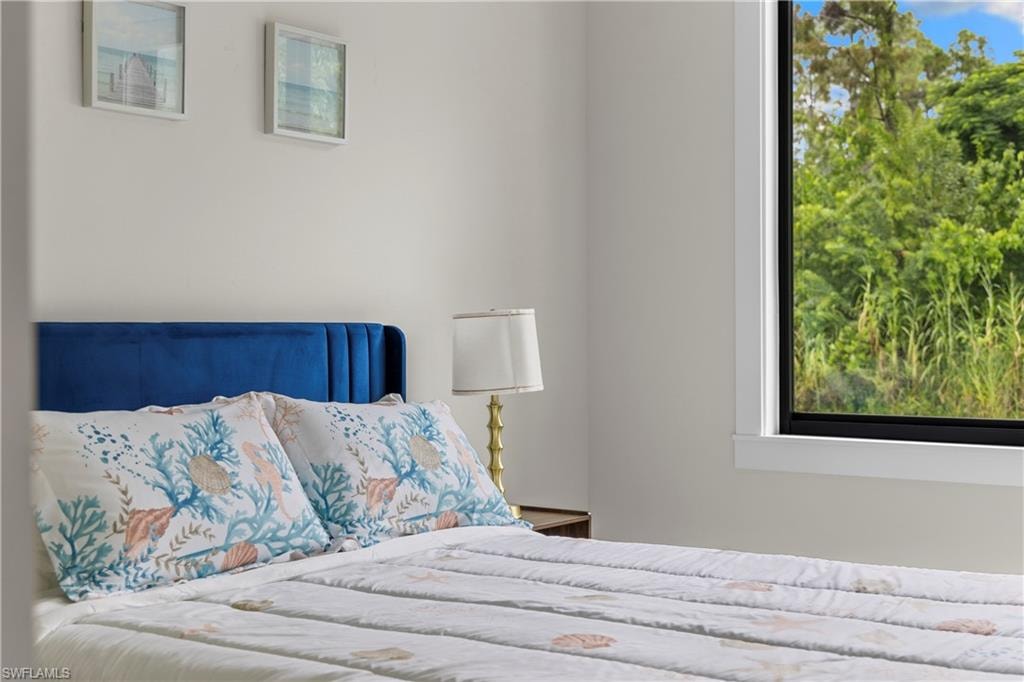 Bright room featuring a large window with white trim, offering expansive views of lush greenery