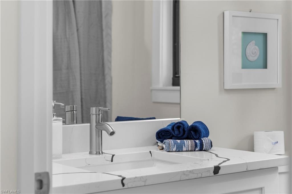Bathroom vanity featuring a single basin sink and a contemporary brushed nickel faucet