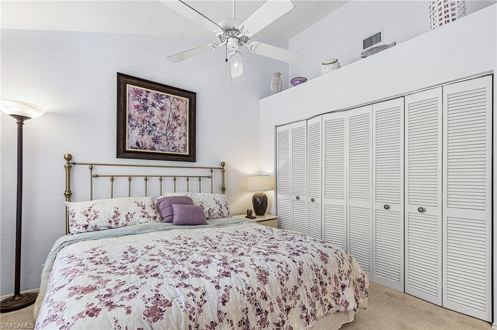Bedroom with carpet, a ceiling fan, a closet, and a high ceiling