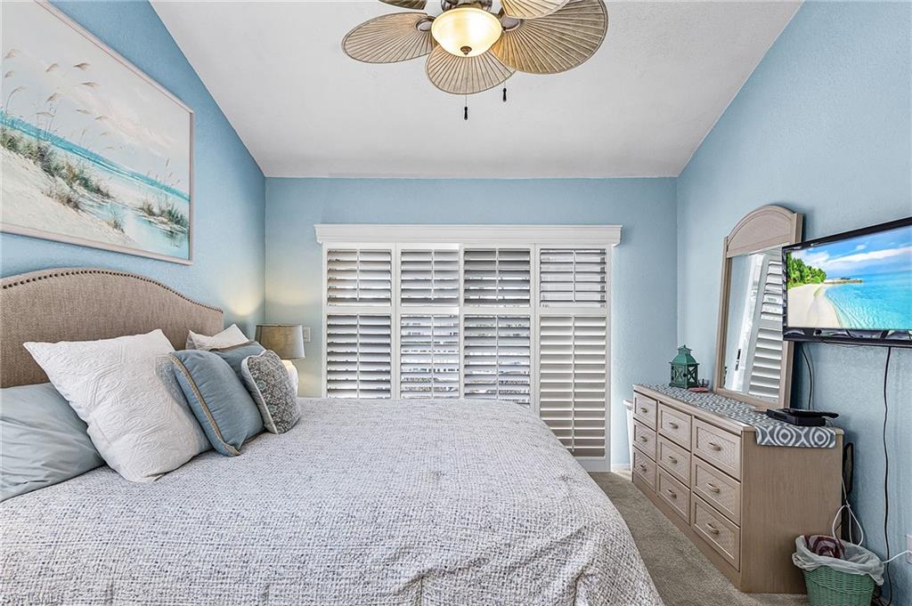 Carpeted bedroom featuring ceiling fan and baseboards