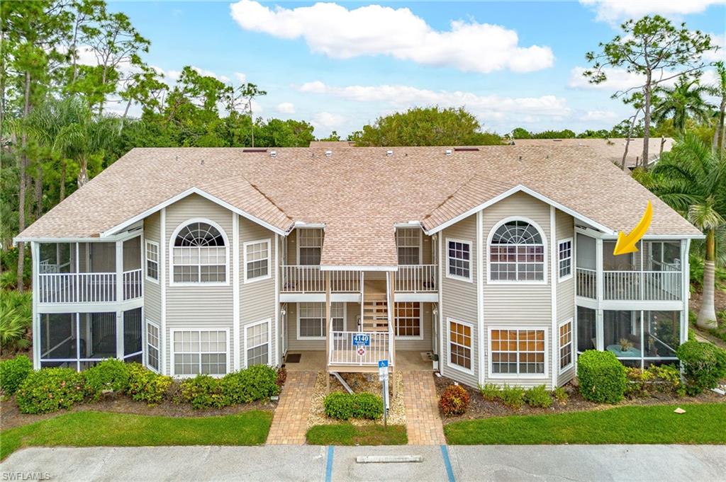 Rear view of property featuring a sunroom and roof with shingles