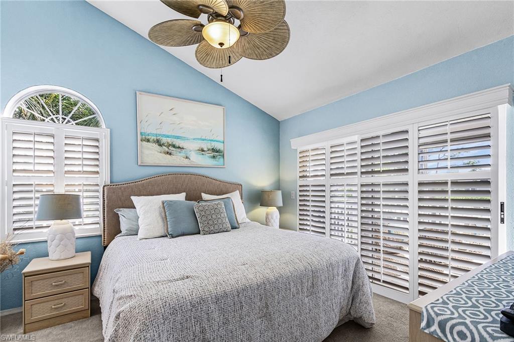 Bedroom featuring carpet flooring, vaulted ceiling, and ceiling fan