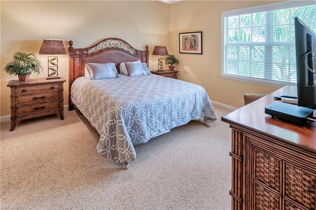 Bedroom featuring light carpet and baseboards