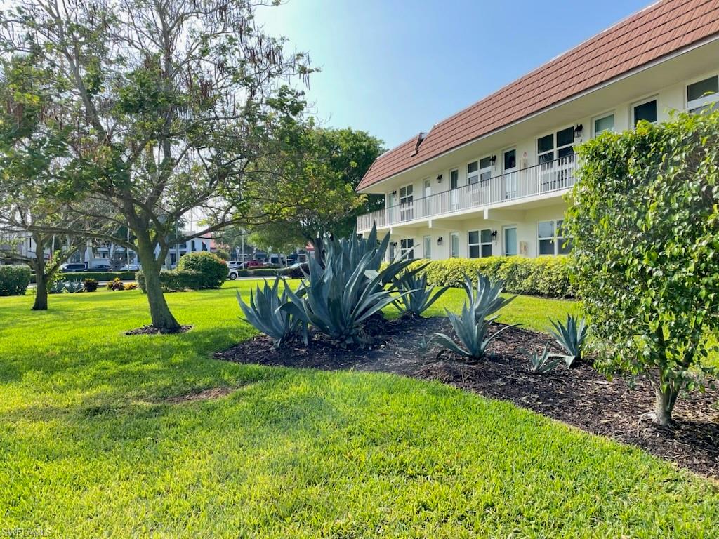 Lush green lawn with mature trees and agave plantings