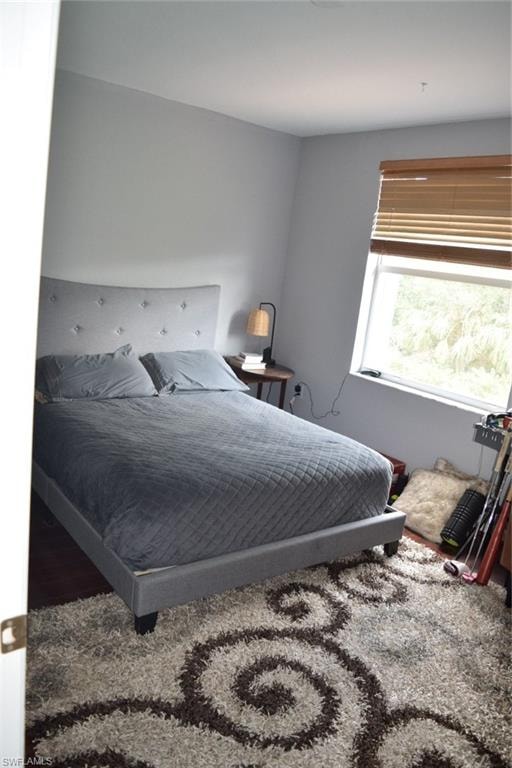 Bedroom featuring light gray walls and wood-finish flooring