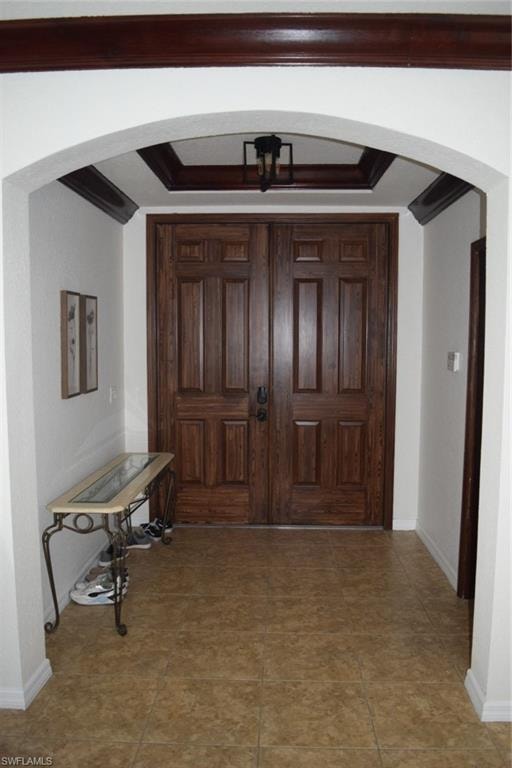 Double wood-panel doors with dark hardware, set within an arched entryway