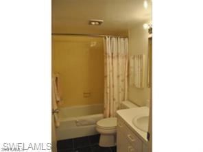 Bathroom with vanity, toilet, and shower / bath combo with shower curtain