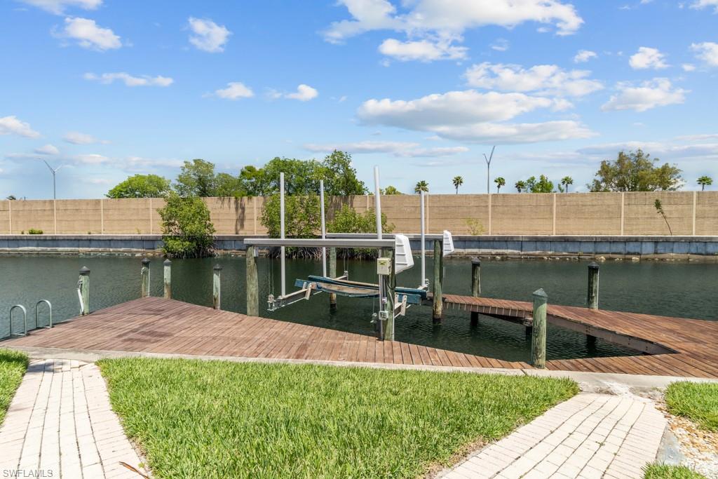 Waterfront backyard featuring a wood dock, boat lift, and canal access