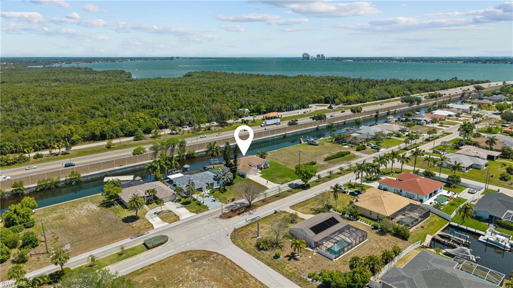 Waterfront property featuring canal access, a concrete dock, and a paver driveway