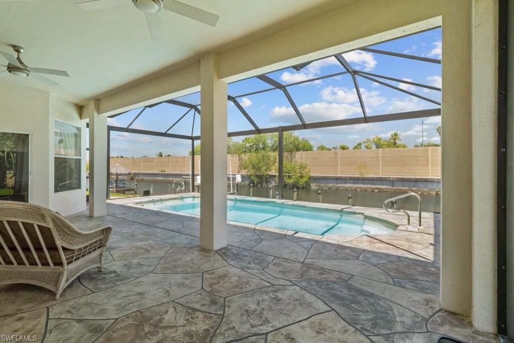 Screened-in patio with stamped concrete flooring, leading to a fenced swimming pool