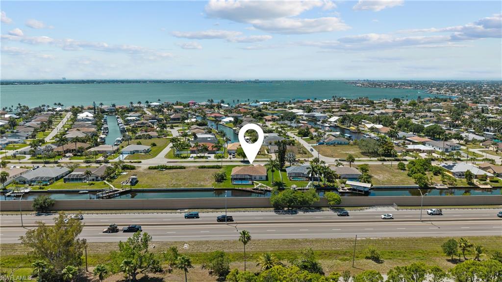 Aerial perspective showcasing a waterfront community with canal access and a distant body of water
